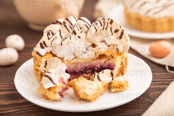 Tartlets with meringue cream and cup of coffee on brown wooden background and linen textile. side view, selective focus. Breakfast, morning, concept