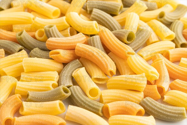 Rigatoni colored raw pasta, texture, background. Side view