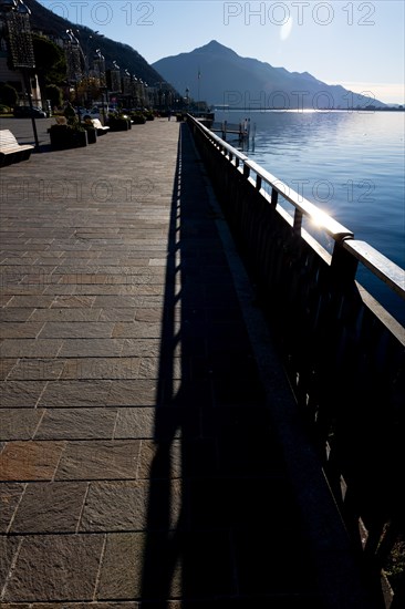 Shadow of a Railing on the Street on the Waterfront to Lake Ceresio in Campione d'Italia, Lombardy, Italy, Europe