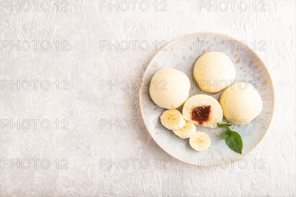 Japanese rice sweet buns mochi filled with jam on a gray concrete background. top view, flat lay, copy space