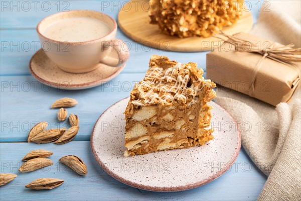 Traditional lithuanian cake shakotis with cup of coffee on blue wooden background and linen textile. side view, close up