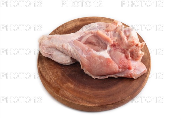 Raw turkey wing on a wooden cutting board isolated on white background. Side view, close up