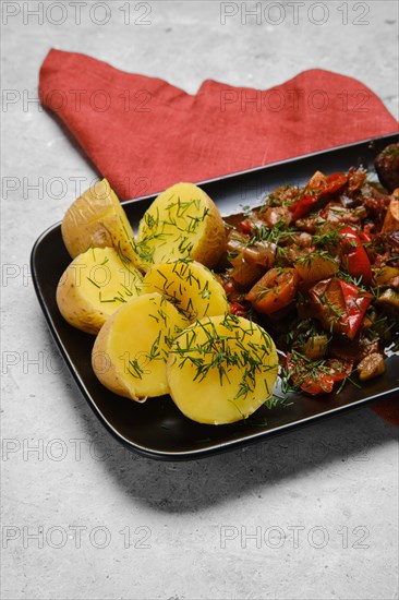 Close up view of boiled potato and chopped vegetables in a plate