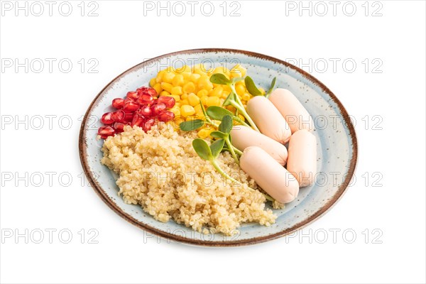 Mixed quinoa porridge, sweet corn, pomegranate seeds and small sausages isolated on white background. Side view, close up. Food for children, healthy food concept