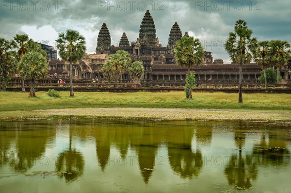 Angkor Wat temple complex in Cambodia with its reflection on water under a cloudy sky. Siem reap, Cambodia, Asia