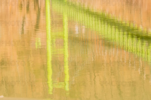 Reflection of green suspension bridge in river below in South Korea