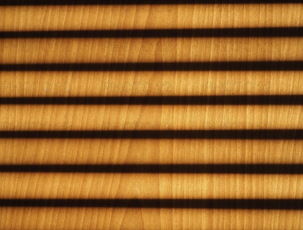 Blinds shadow on wooden wall background