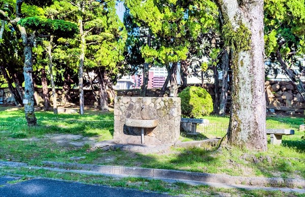 Old stone and concrete water fountain in urban park in Hiroshima, Japan, Asia