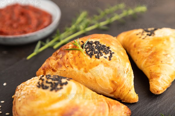 Homemade asian pastry samosa on black concrete background. side view, selective focus