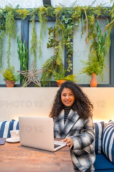 Vertical portrait with copy space of a young entrepreneur working in a cafeteria