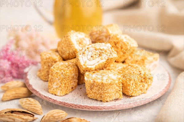Traditional turkish delight (rahat lokum) with glass of green tea on a gray concrete background and linen textile. side view, selective focus, close up