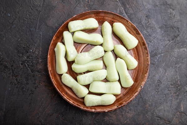 Jelly celery candies on black concrete background, top view, flat lay, close up