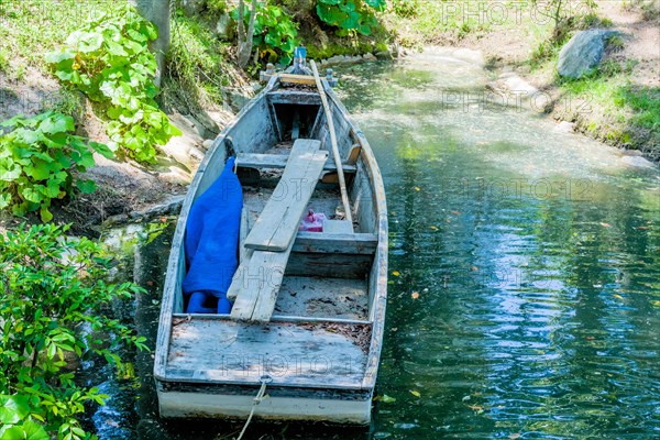 Wooden row boat at shore of lake in Japanese Shukkeien Gardens in Hiroshima, Japan, Asia