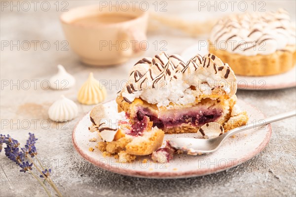 Two tartlets with meringue cream and cup of coffee on brown concrete background. side view, selective focus. Breakfast, morning, concept