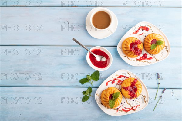 Semolina cheesecake with strawberry jam, lavender, cup of coffee on blue wooden background. top view, flat lay, copy space