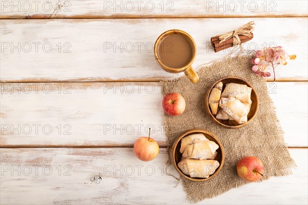 Homemade sweet cookie with apple jam and cup of coffee on white wooden background and linen textile. top view, flat lay, copy space