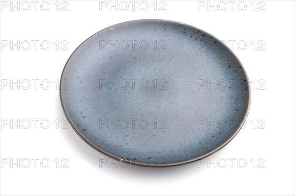 Empty blue ceramic plate isolated on white background. Side view, close up