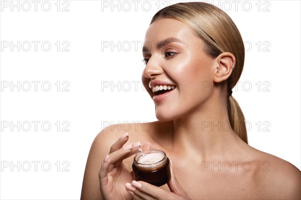 Beauty portrait of model with natural make-up holding a jar of cream. Fashion shiny highlighter on skin, sexy gloss lips make-up High quality photo