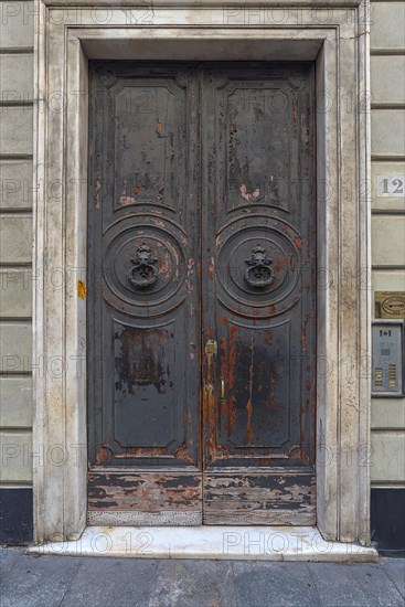 Two door knockers with lion heads on a large entrance door in the historic centre, Genoa, Italy, Europe