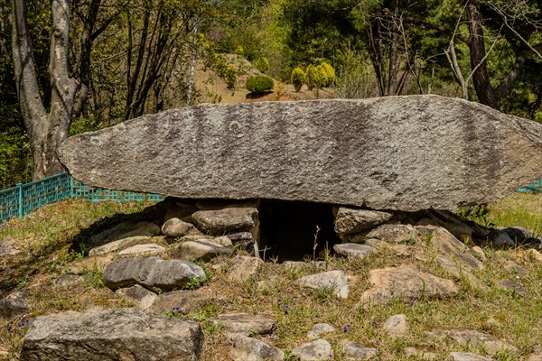 Large boulder covering opening to burial camber in public park in South Korea