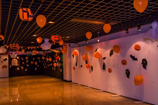 Dimly lit room decorated with hand made Halloween decorations of ghost, jack-o-lanterns and balloons in South Korea