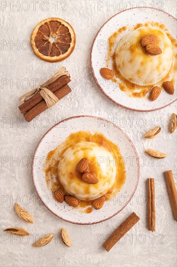 White milk jelly with caramel sauce on gray concrete background. top view, flat lay