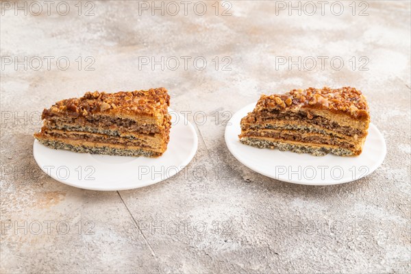 Walnut and hazelnut cake with caramel cream on brown concrete background. side view
