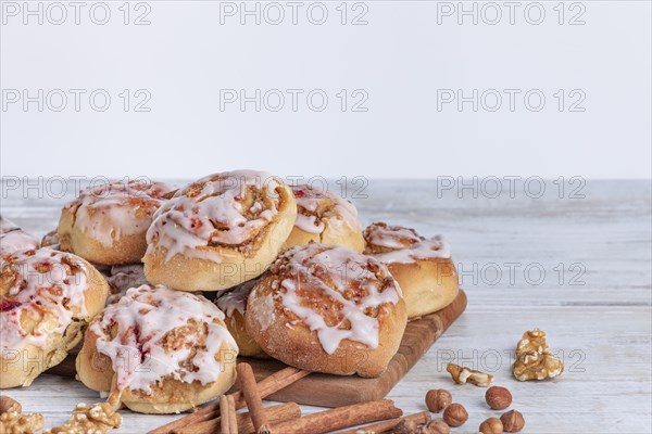 Delicious cinnamon biscuits with nuts and icing on a wooden base