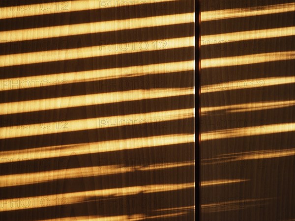 Blinds shadow on wooden wall background