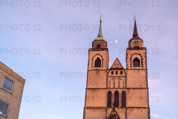 Pink-coloured sky behind the twin towers of St. John's Church at dusk, Magdeburg, Saxony-Anhalt, Germany, Europe