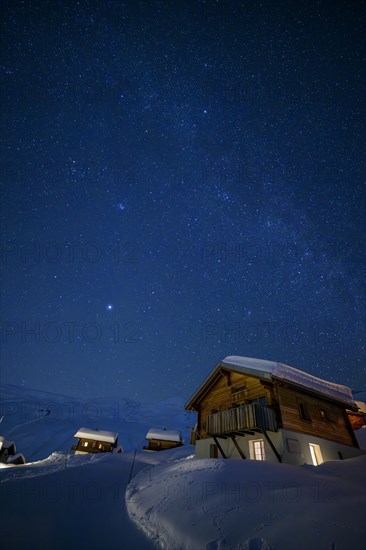 Mountain huts at night under a clear starry sky with illuminated windows in winter, Belalp, Naters, Brig, Canton Valais, Switzerland, Europe