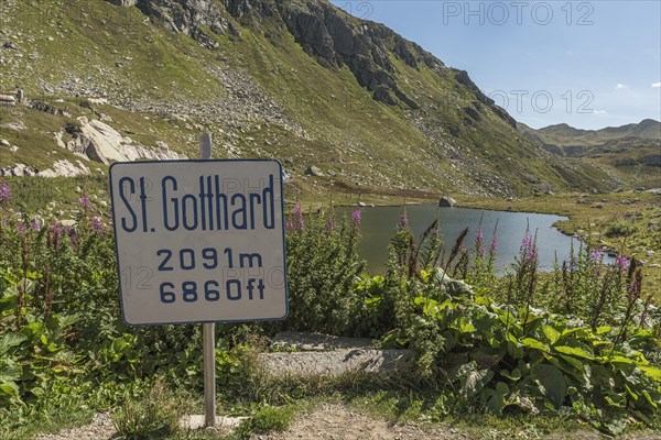 Gotthard Pass, mountain lake and sign with altitude information at the top of the pass, Canton Ticino, Switzerland, Europe