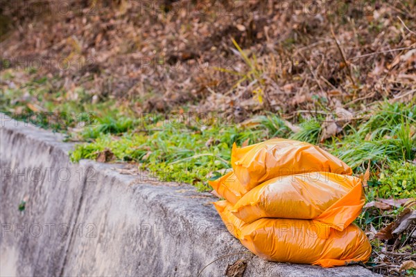 Orange bags of sand stacked on curb of mountain roadside