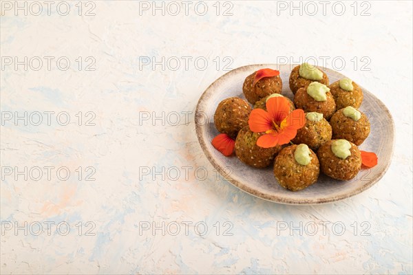 Falafel with guacamole on white concrete background. Side view, copy space