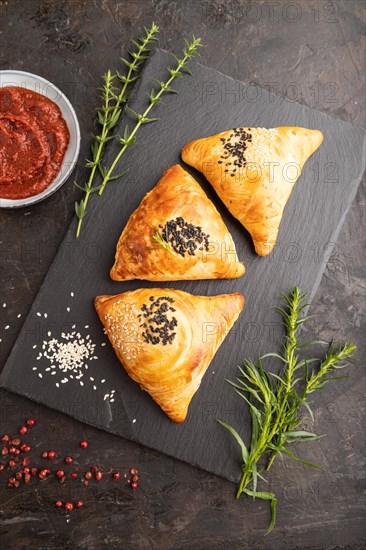 Homemade asian pastry samosa on black concrete background. top view, flat lay, close up