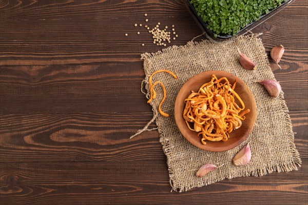 Fresh Cordyceps militaris mushrooms on brown wooden background with microgreen, herbs and spices. Top view, flat lay, copy space