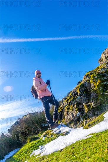 Portrait of a man on the top of the mountain while trekking, walking with a cane