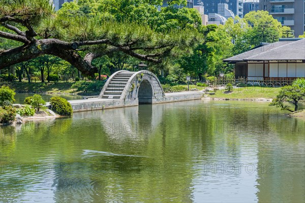 Concrete bridge over man made lake in Shukkeien gardens in Hiroshima, Japan, Asia