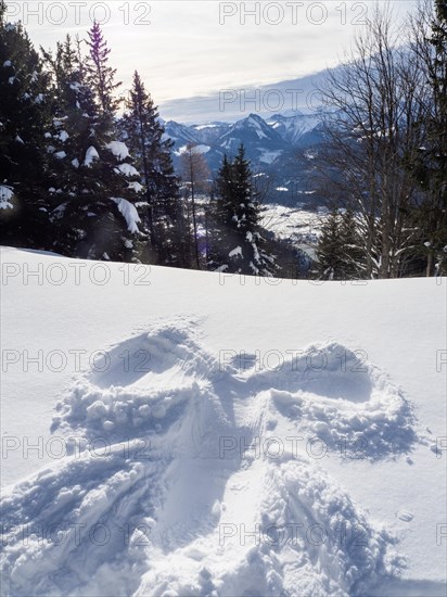 Winter atmosphere, snow-covered landscape, snow-covered Alpine peaks, angel figure in the snow, near St. Wolfgang am Wolfgangsee, Salzkammergut, Upper Austria, Austria, Europe