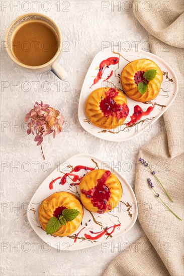 Semolina cheesecake with strawberry jam, lavender, cup of coffee on gray concrete background and linen textile. top view, flat lay, close up