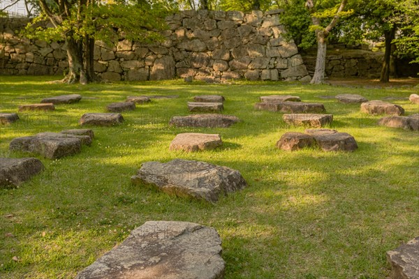 Large flat foundation stones in green lawn of nature park in Hiroshima, Japan, Asia