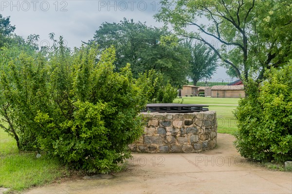 Side view of old stone water well with wooden cover in public park in South Korea