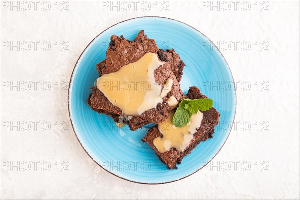 Chocolate brownie with caramel sauce on gray concrete background. top view, flat lay, close up