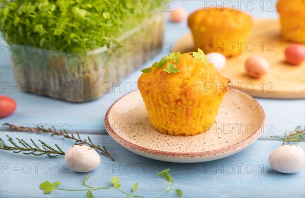 Homemade cakes with chocolate eggs and spinach microgreen on a blue wooden background. side view, close up, selective focus