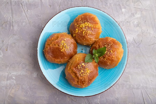 Homemade traditional turkish dessert sekerpare with almonds and honey on gray concrete background. top view, flat lay, close up