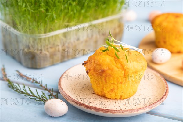 Homemade cakes with chocolate eggs and carrot microgreen on a blue wooden background. side view, close up, selective focus
