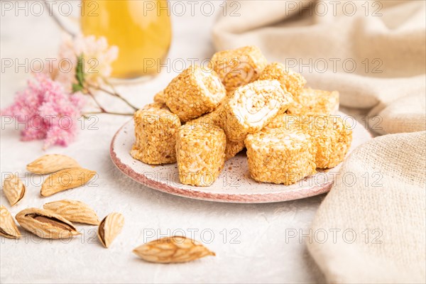 Traditional turkish delight (rahat lokum) with glass of green tea on a gray concrete background and linen textile. side view, selective focus, close up
