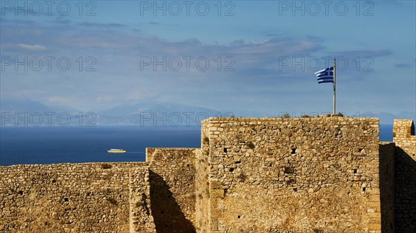 Historic fortress walls under a partly cloudy sky with Greek flag and sea view, Chlemoutsi, High Medieval Crusader Castle, Kyllini Peninsula, Peloponnese, Greece, Europe