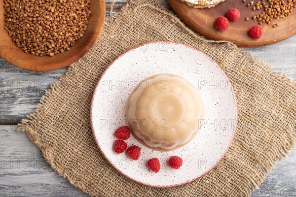 Buckwheat milk jelly on gray wooden background and linen textile. top view, flat lay