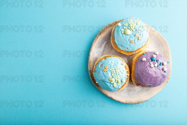 Purple and blue glazed donut on blue pastel background. top view, flat lay, copy space. Breakfast, morning, concept